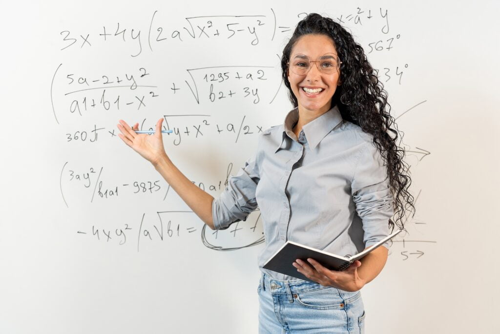 female math teacher showing equations on a whiteboard