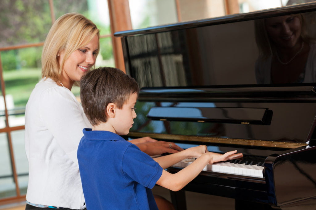 Piano Teacher With Young Boy Student